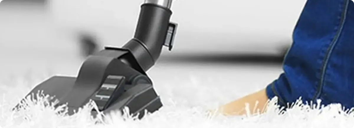 Close-up of a professional vacuuming a white carpet in Moraga.